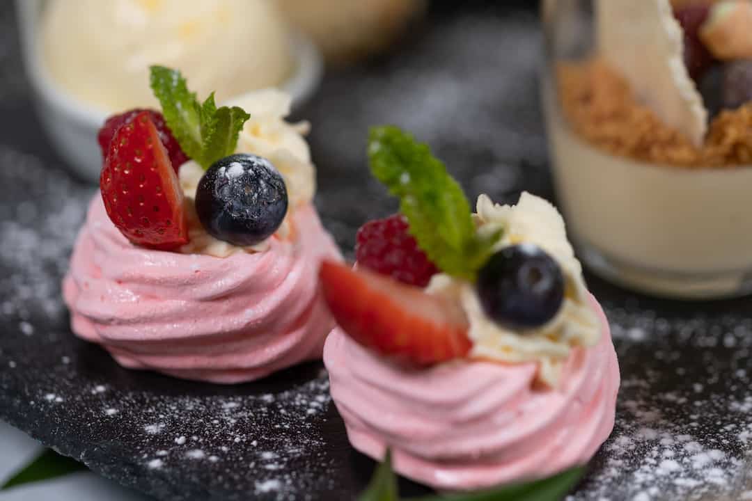 Close up of Mini Pavlova's topped with berries ready for Pink Afternoon Tea